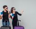 Smiling young happy couple with  suitcases and ticket around isolated on white background. Copy space. Place for some text.